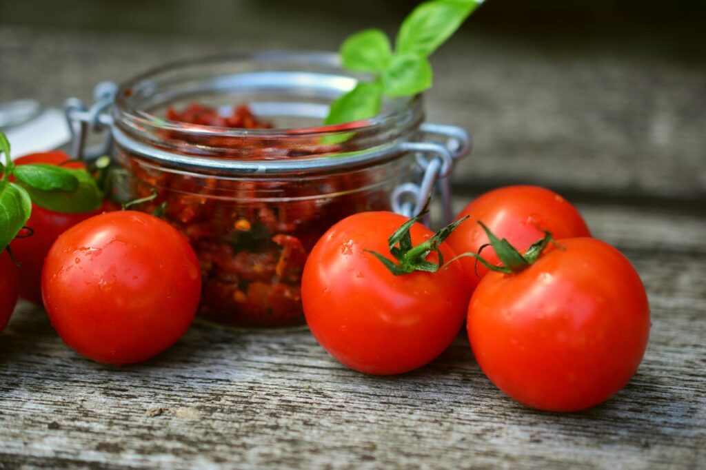 Red Tomatoes Near Glass Jar